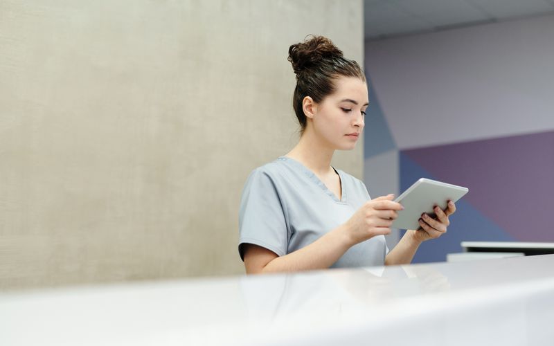 A nurse checking readings on a tablet