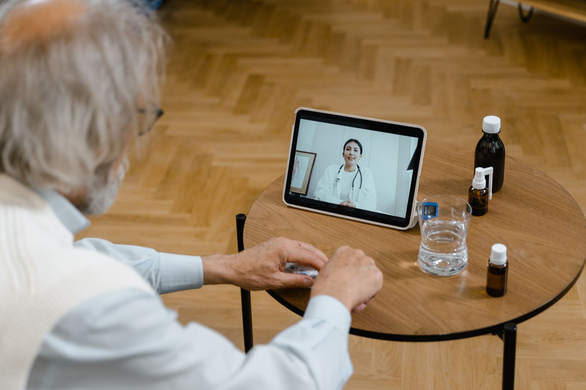 An older man at home on a video visit with his clinician on a tablet