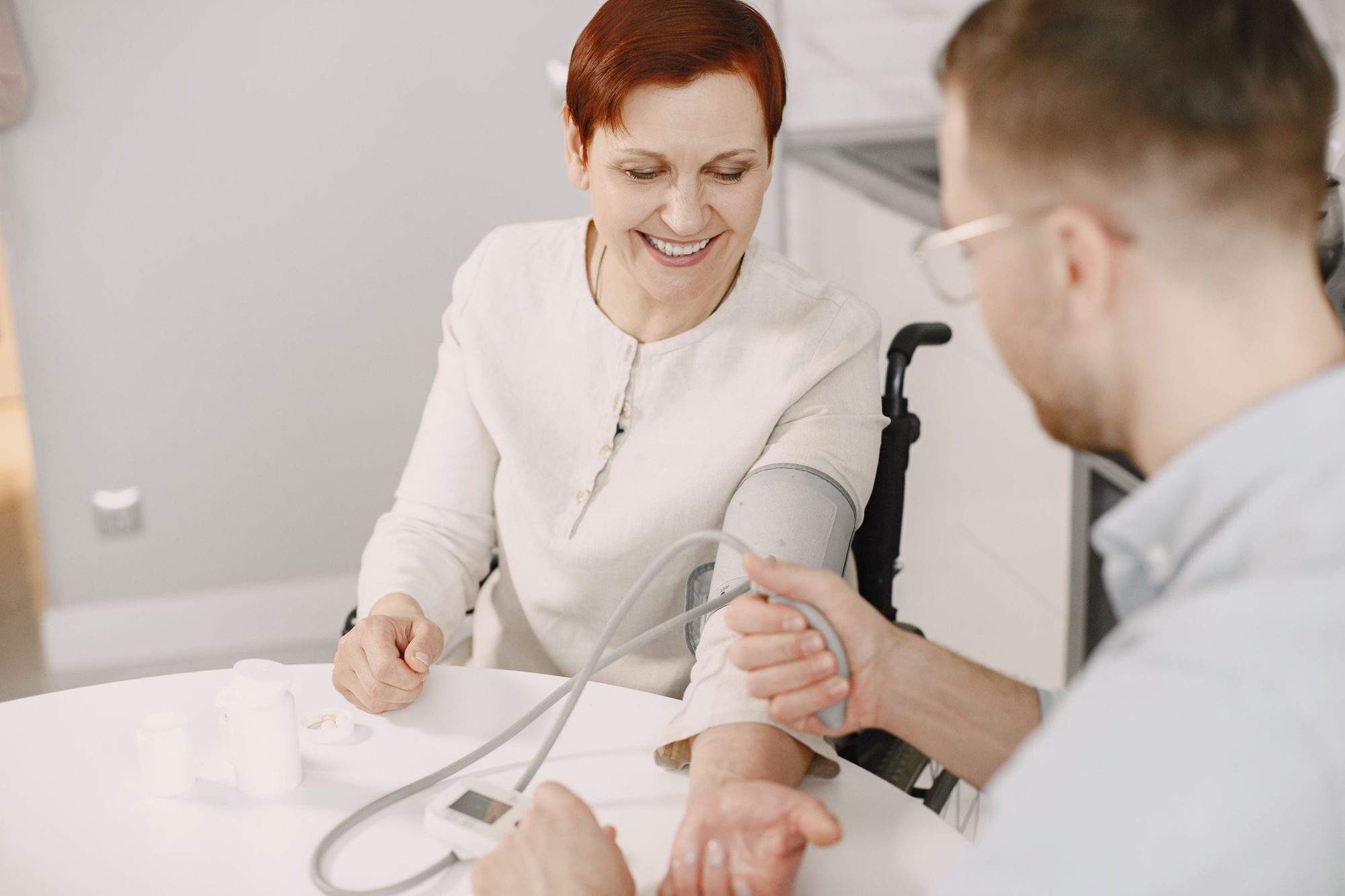 A smiling patient having her blood pressure taken at home