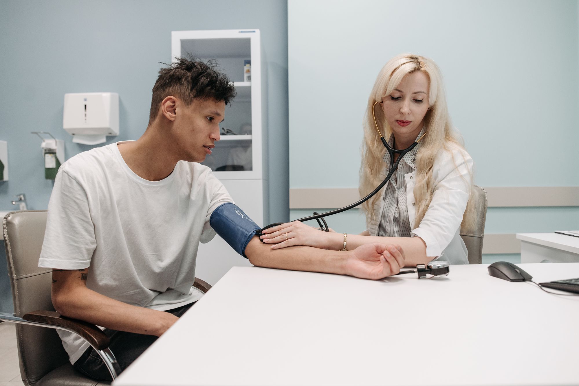 A clinician taking a patient's blood pressure in the clinic