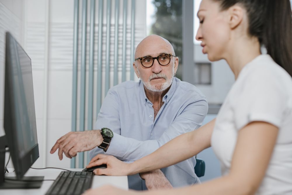 A clinician going over trends on screen with an older patient